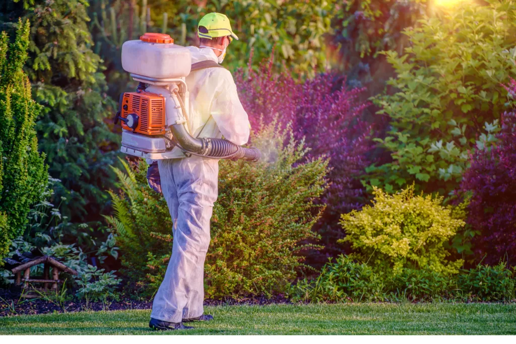 pest control worker spraying yard landscaping