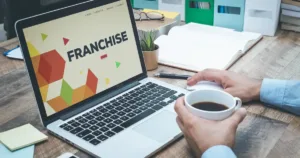 Corporate professional reviewing home service franchise opportunities on a laptop